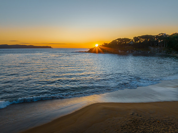 Aerial sunrise seascape with calm seas and a clear sky