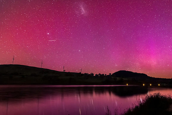 Aurora Australis display lights up the sky in pinks over the dam