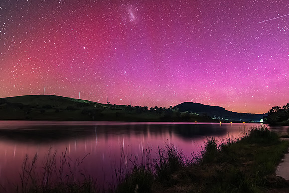 Aurora Australis display lights up the sky in pinks over the dam