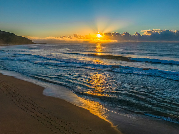 Sunrise over the sea with a low cloud bank and fog