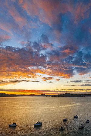 Aerial sunrise over the bay with boats and clouds