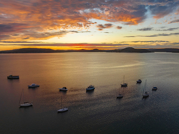 Aerial sunrise over the bay with boats and clouds