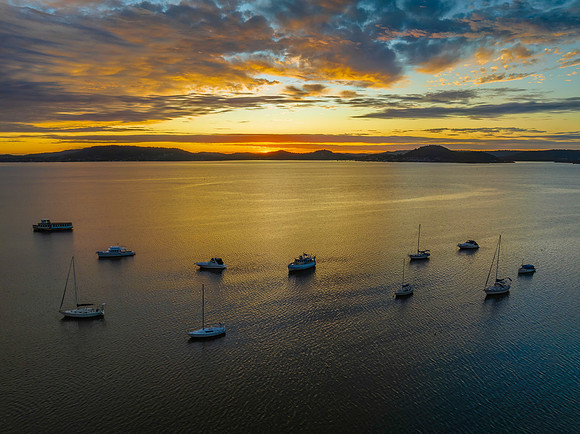 Aerial sunrise over the bay with boats and clouds