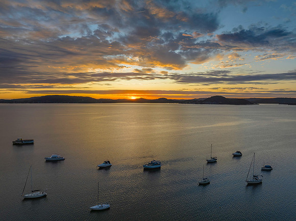 Aerial sunrise over the bay with boats and clouds