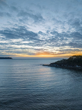 Aerial sunrise seascape with calm seas and a mix of low and medi