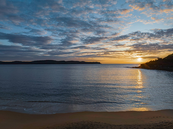 Aerial sunrise seascape with calm seas and a mix of low and medi