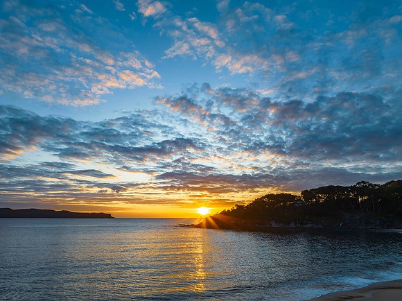 Aerial sunrise seascape with calm seas and a mix of low and medi