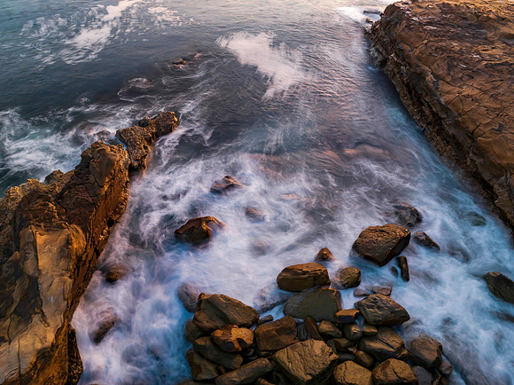 Top down sunrise over the ocean with rocks