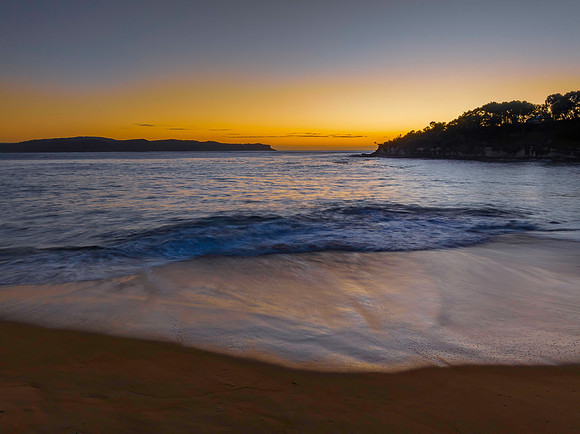 Aerial sunrise seascape with calm seas and a clear sky