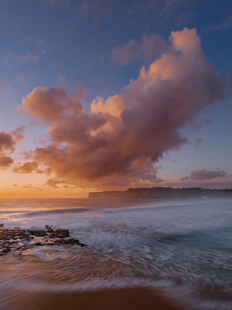 Surfs up sunrise at the seaside with scattered clouds