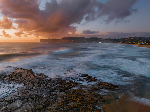 Surfs up sunrise at the seaside with scattered clouds