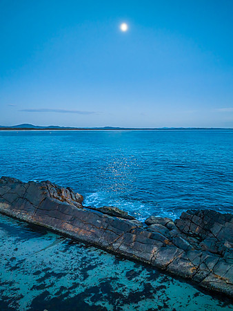 Blue Dawn and Moonlight fall across Coastal Rock Formations