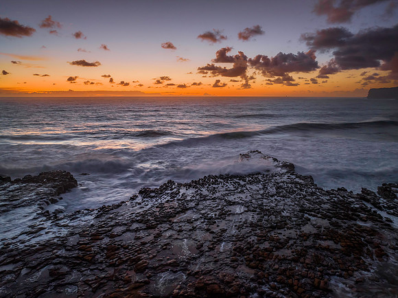 Surfs up sunrise at the seaside with scattered clouds