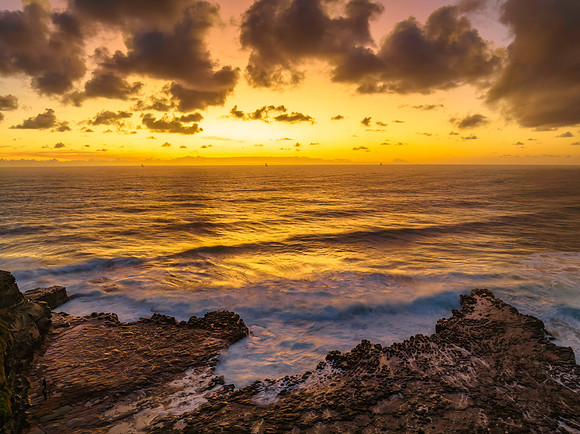 Surfs up sunrise at the seaside with scattered clouds
