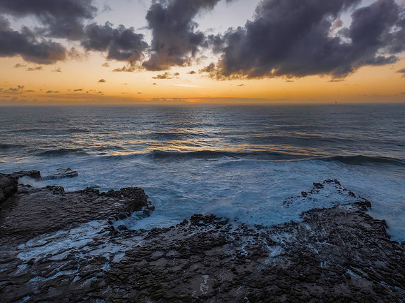 Surfs up sunrise at the seaside with scattered clouds