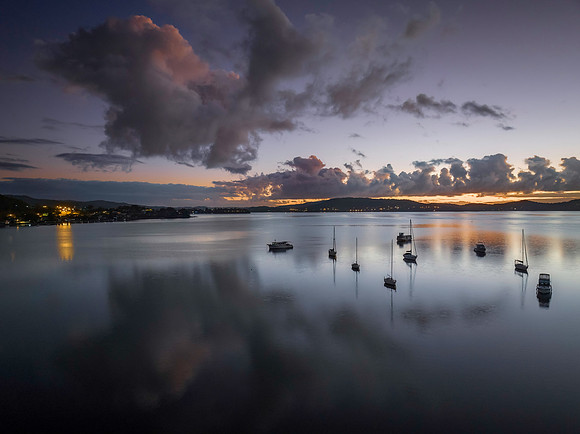 Aerial sunrise waterscape with boats, clouds and reflections