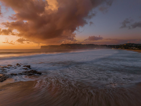 Surfs up sunrise at the seaside with scattered clouds