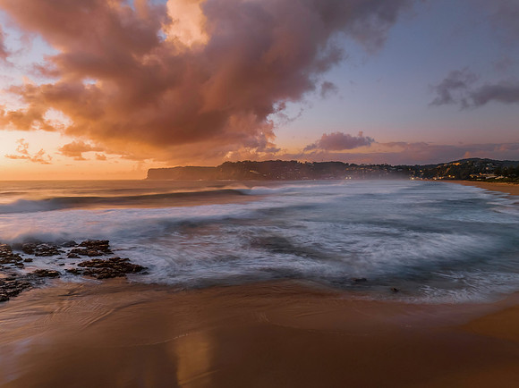 Surfs up sunrise at the seaside with scattered clouds
