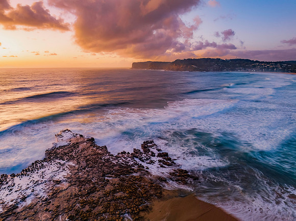 Surfs up sunrise at the seaside with scattered clouds