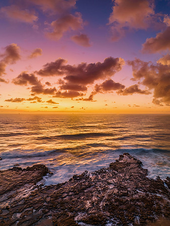 Surfs up sunrise at the seaside with scattered clouds