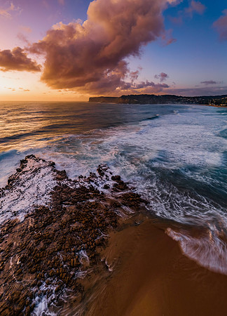 Surfs up sunrise at the seaside with scattered clouds