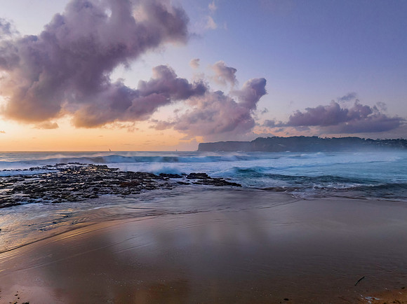 Surfs up sunrise at the seaside with scattered clouds