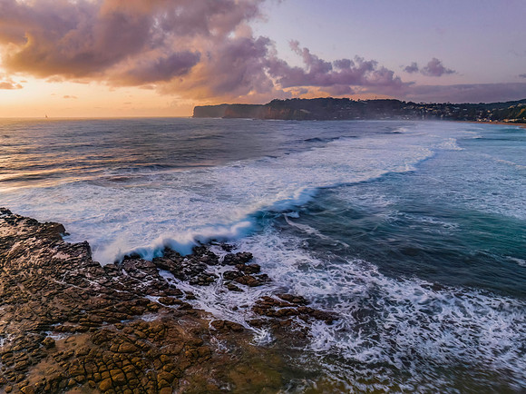 Surfs up sunrise at the seaside with scattered clouds