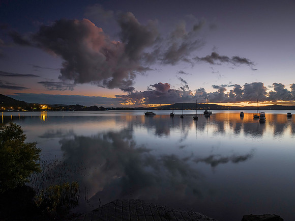 Aerial sunrise waterscape with boats, clouds and reflections