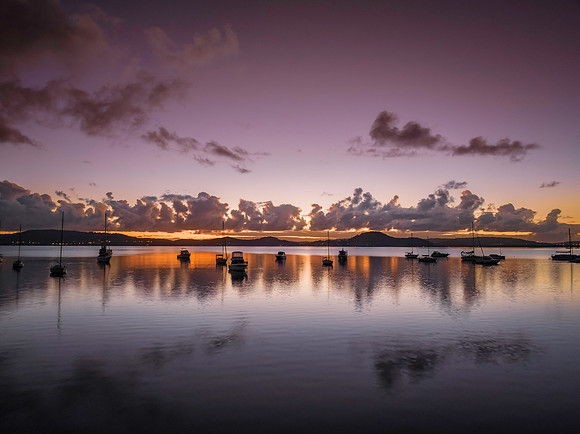 Aerial sunrise waterscape with boats, clouds and reflections