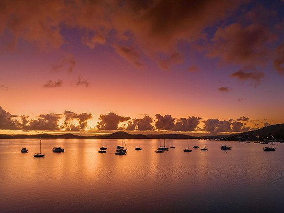 Aerial sunrise waterscape with boats, clouds and reflections