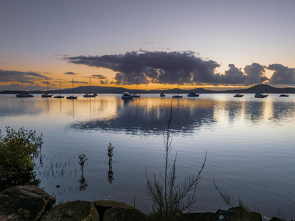Aerial sunrise waterscape with boats, clouds and reflections