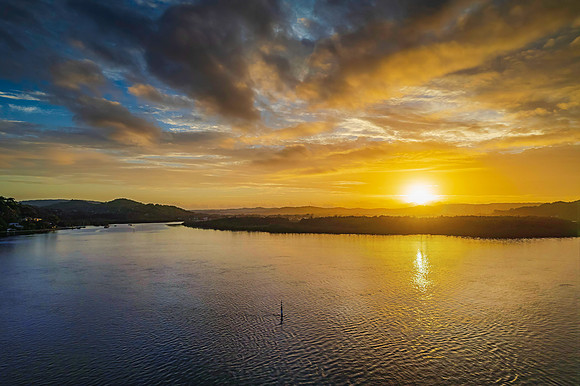 Sunrise waterscape with a mix of low, medium and high clouds