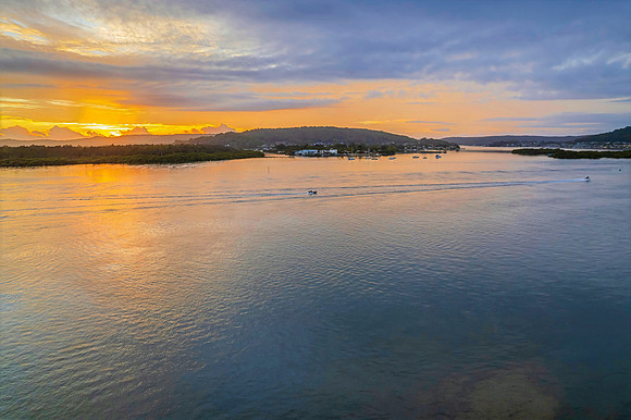 Sunrise waterscape with a mix of low, medium and high clouds