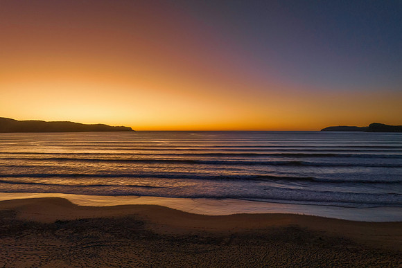 Clear skies aerial sunrise seascape with an orange glow