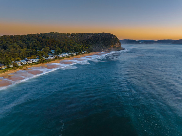Aerial sunrise seascape with calm seas and a clear sky