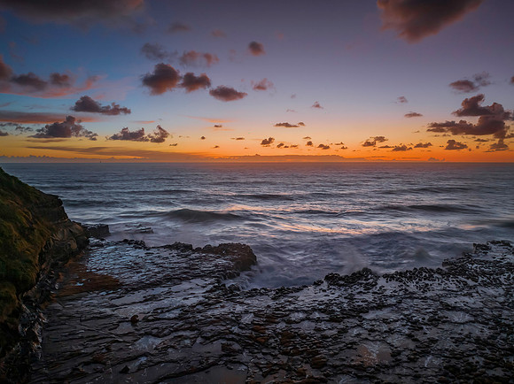 Surfs up sunrise at the seaside with scattered clouds