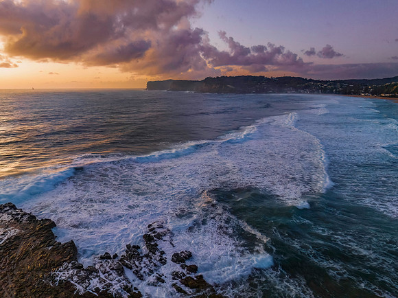 Surfs up sunrise at the seaside with scattered clouds