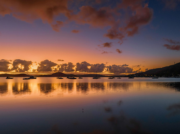 Aerial sunrise waterscape with boats, clouds and reflections
