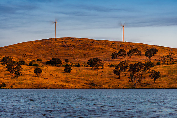 Twilight Light Falls Over the Dam as the Wind Turbines Spin