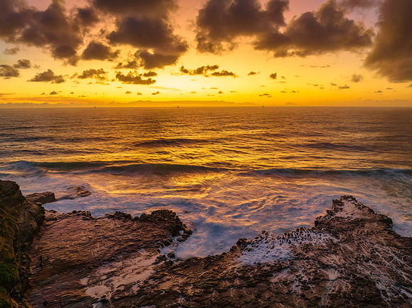 Surfs up sunrise at the seaside with scattered clouds