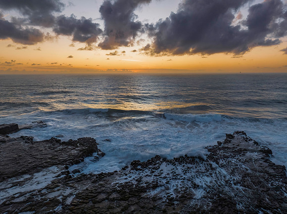 Surfs up sunrise at the seaside with scattered clouds