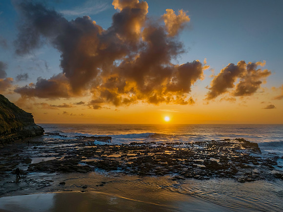 Surfs up sunrise at the seaside with scattered clouds