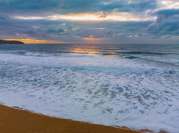 Sunrise and a cloud covered sky at the beach