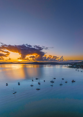 Aerial sunrise waterscape with boats, clouds and reflections