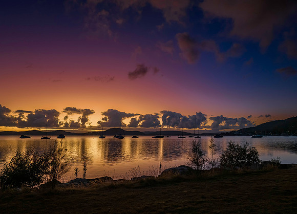 Aerial sunrise waterscape with boats, clouds and reflections