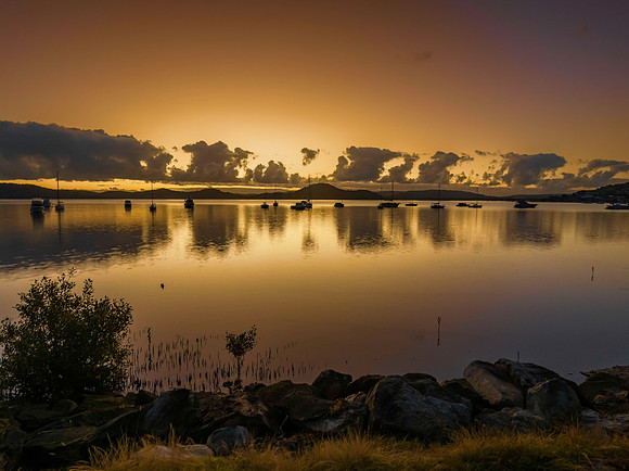 Aerial sunrise waterscape with boats and clouds in soft rose gol