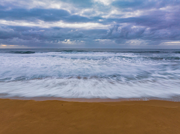 Sunrise and a cloud covered sky at the beach