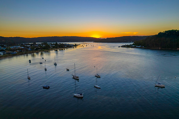 Aerial sunrise waterscape with boats and clear skies