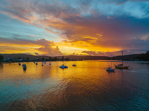 Aerial sunrise waterscape with boats, colour and clouds