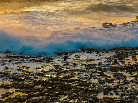 Top down sea water over rock platform in the sunrise light